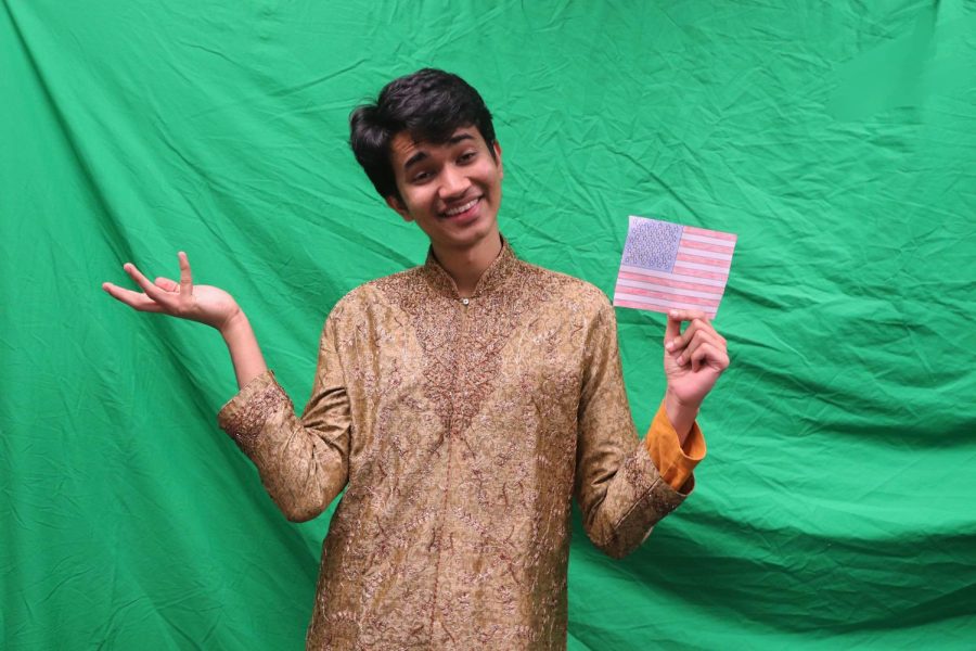 Writer Pranav Mishra wears traditional Indian clothing while holding a U.S. flag.