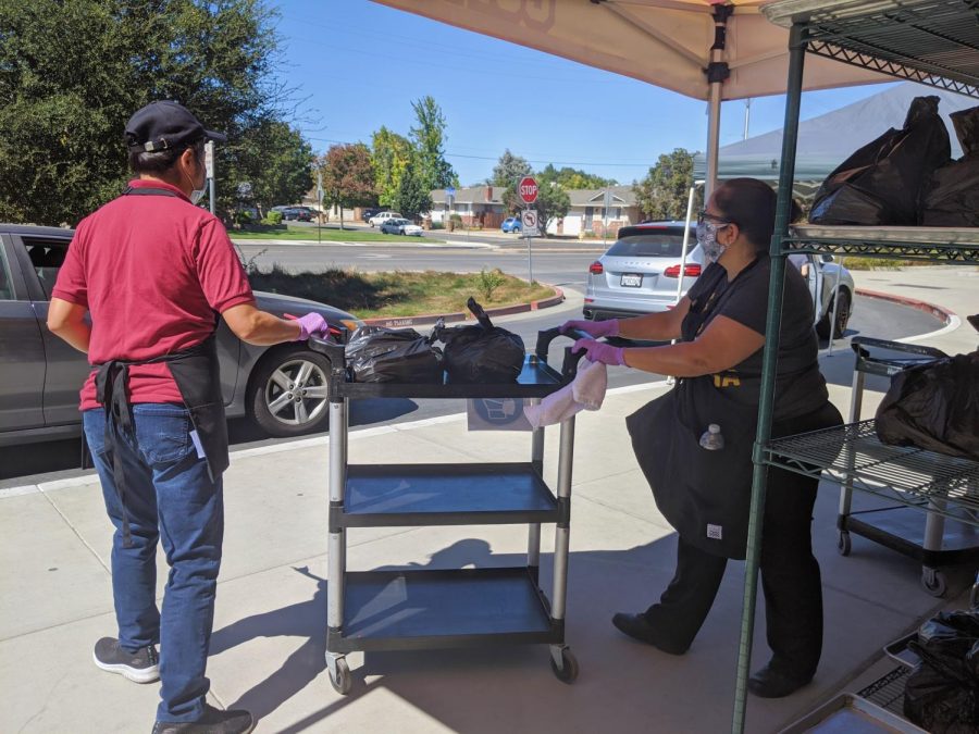 A cart with wheels is used to distribute meals in the drive-through pickup process so staff and parents or students can maintain social distance.