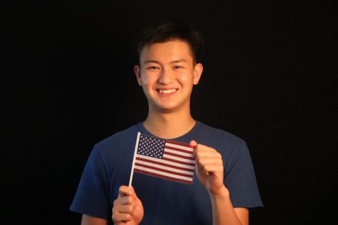 Staffer Bennie Chang holds up a mini American flag, symbolizing his love for politics.