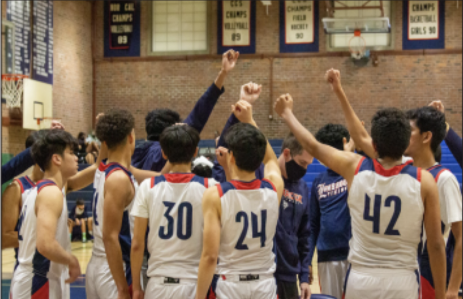 The boys varsity basketball team celebrates a win against Monta Vista High School. 