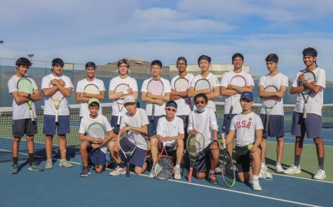 The boys tennis team poses for a photo on the tennis courts.
