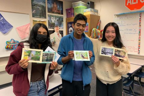 Anish and ArtReach members holding up their completed cards, each with a wildlife photograph.