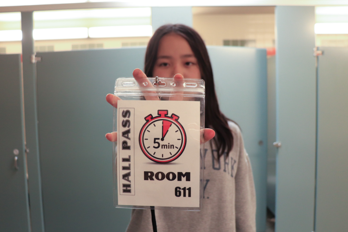 Students can be seen holding this bathroom pass signal their exit from class to go to the restroom. As the image of the clock suggests, bathroom breaks are now limited to five minutes .